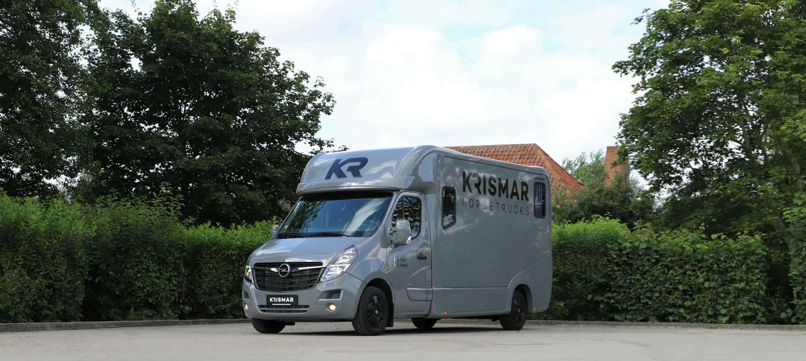 Een grijze Krismar paardenvrachtwagen voor 2 paarden gebouwd op een Opel chassis.