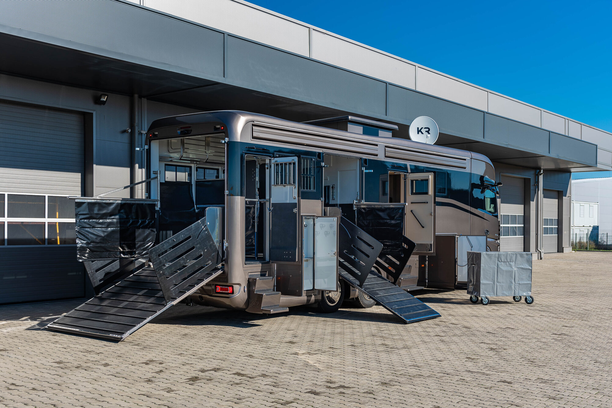 A brown Krismar horse truck with both loading ramps open.