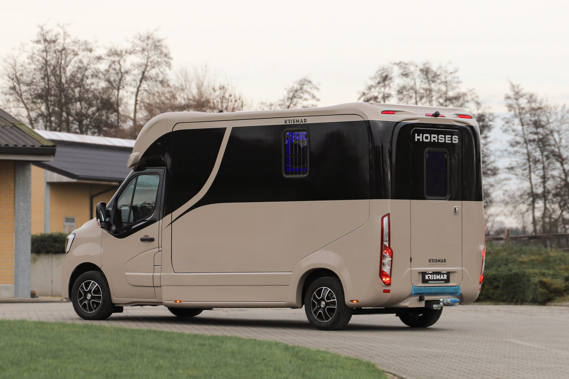 Side view of a gold Krismar 2-horse van with the unmistakable black optical Krismar line.
