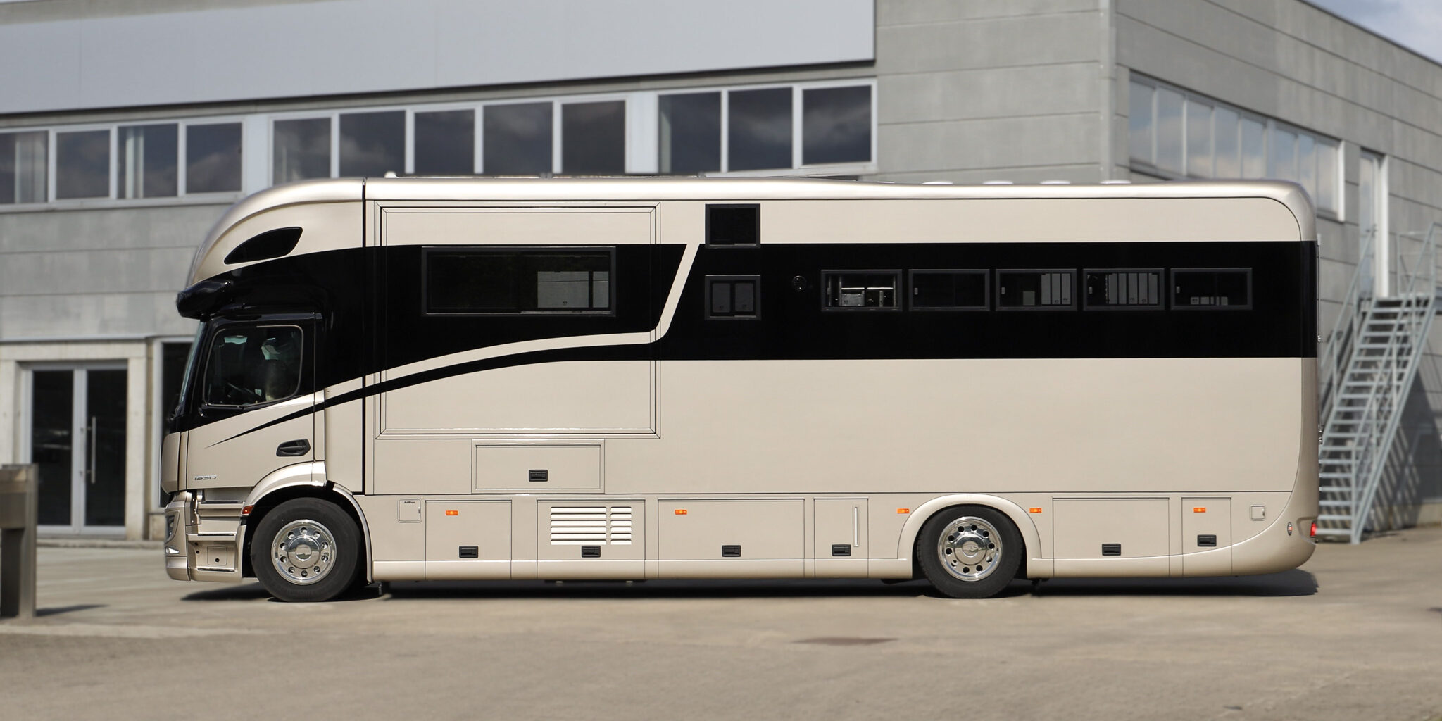 Side view of a Krismar horse truck painted in a gold color with the beloved black Krismar-line.